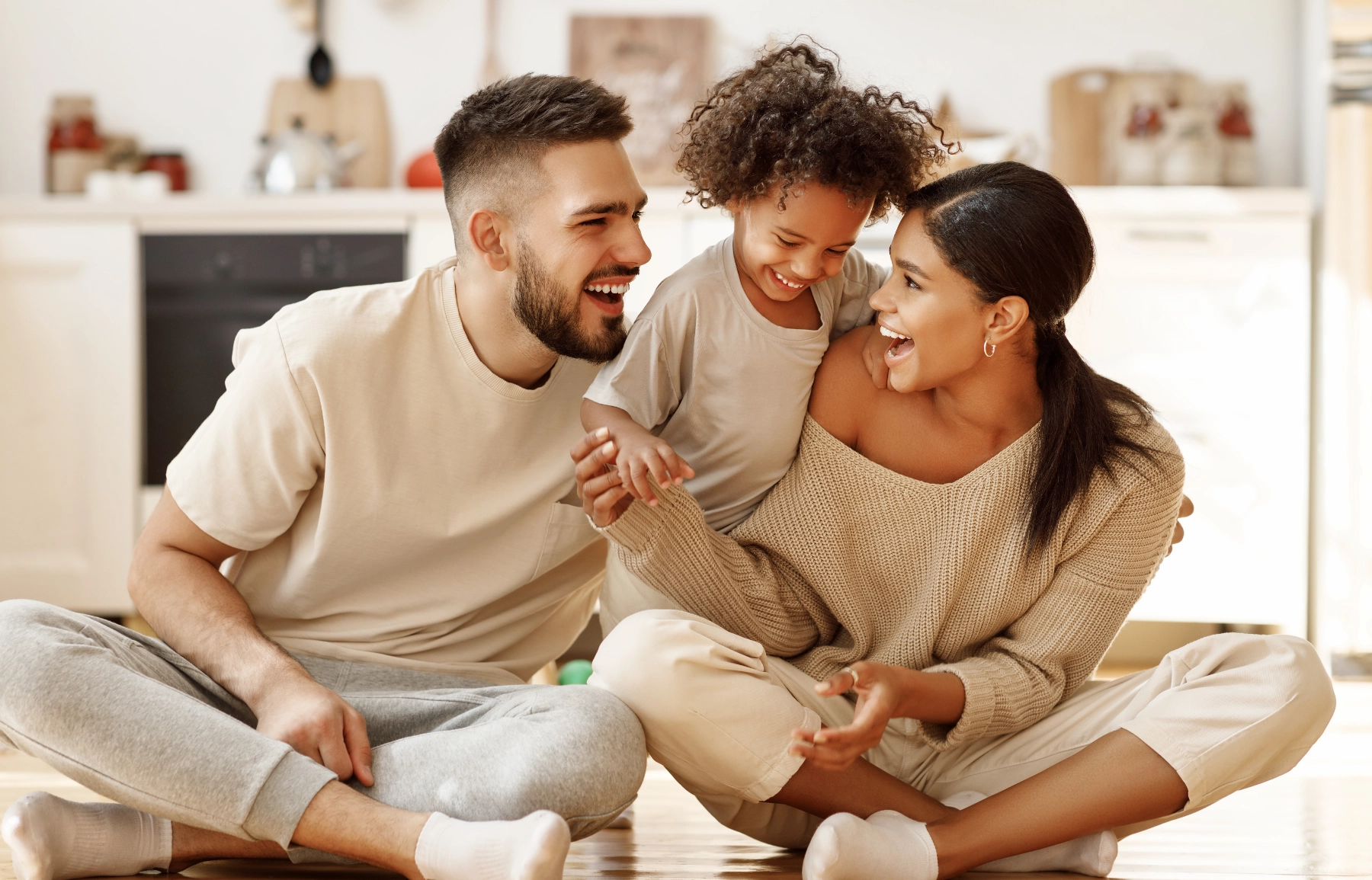Family laughing together at dinner table in warm evening light